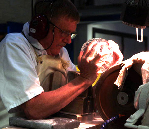 Man cutting crystal on diamond wheel.