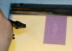 After exposure, the masks are placed in a wash-out unit and washed using clear water. The 'raw' parts wash away. Sandblasting mask being washed out in wash-out unit.